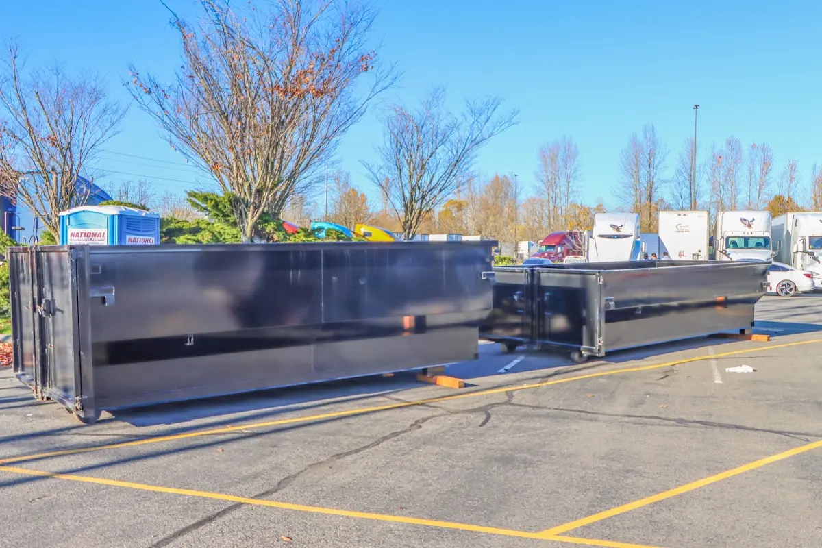 Professional dumpster rental service with roll-off container on residential driveway in Redan